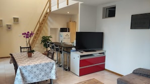 A modern living room with a dining area, a TV, and a staircase. - House near the train station with outdoor space (Neufchâteau)