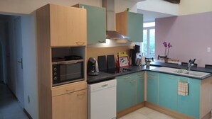 A kitchen with a microwave, stove, and dishwasher, wooden cabinets, and teal-colored lower cabinets. - House near the train station with outdoor space (Neufchâteau)