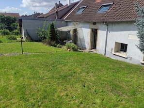Ein Wohnhaus mit Satteldach, kleinem Garten und separater Garage.