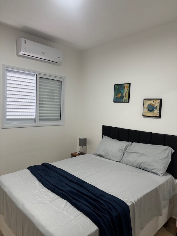 Tabla de planchar con plancha, internet y ropa de cama