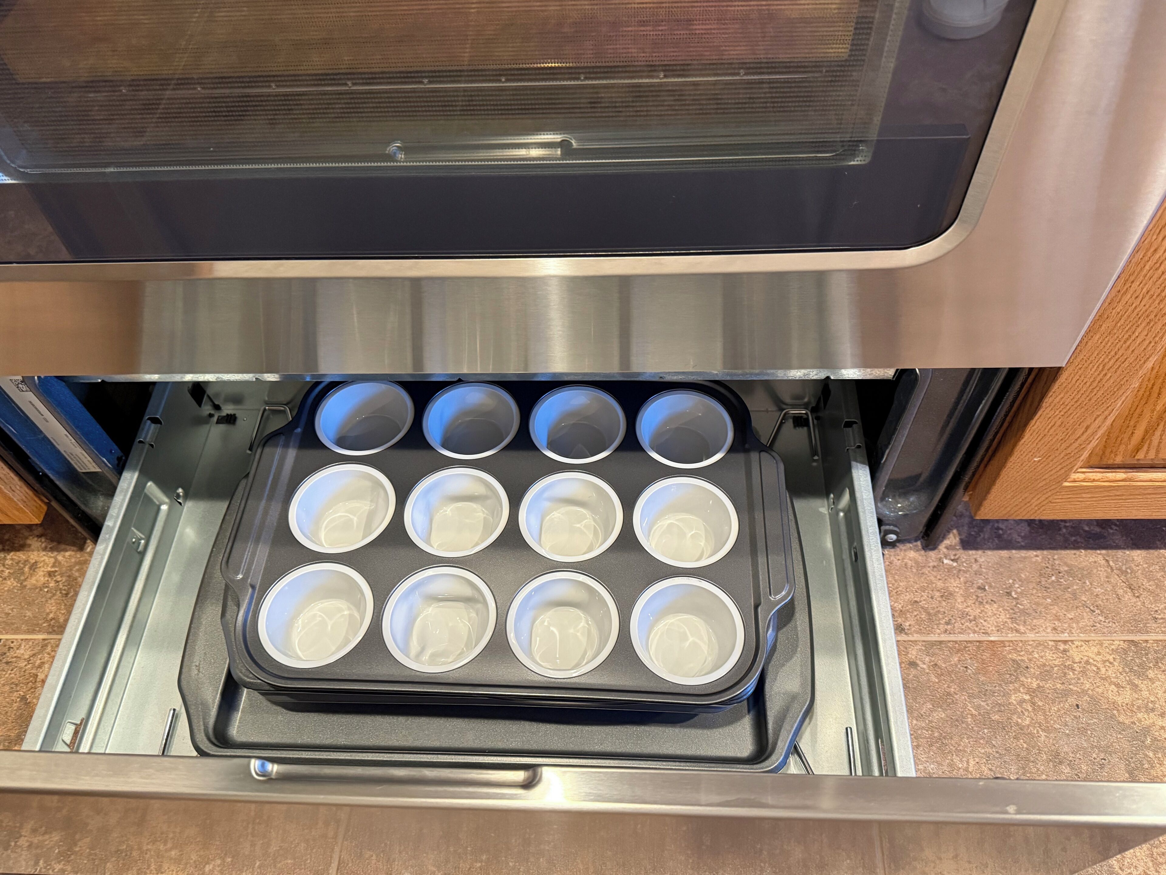 A stainless steel oven with a muffin tray inside.