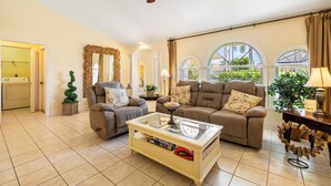 A spacious living room with two sofas, a glass coffee table, and a ceiling fan. - Relaxing outdoor with pool and hot tub! (Cape Coral)