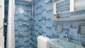 A bathroom with blue tiles, a toilet, a sink, and a shower. - Apartment 'Le Coq' with Balcony, Wi-Fi and Air Conditioning (Mykonos)