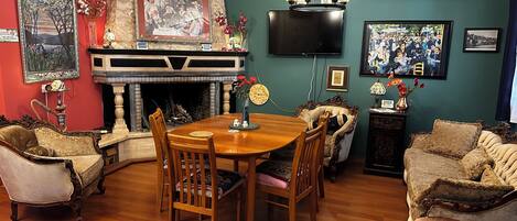 A traditional living room with a fireplace, a dining table, and comfortable seating.