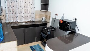A kitchen with a stove, microwave, and a sink.