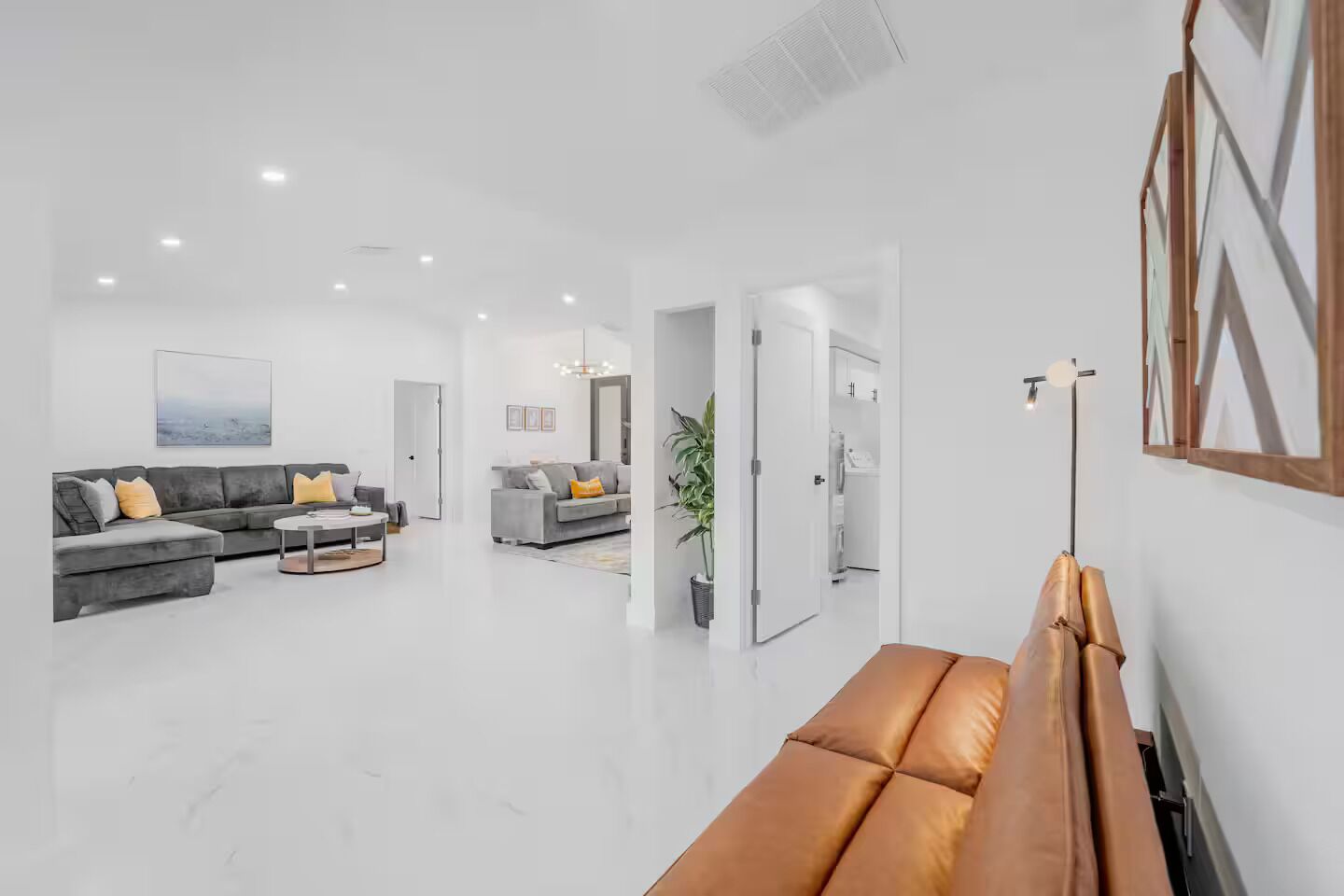 A spacious living area with a grey sofa, a coffee table, and a brown bench.