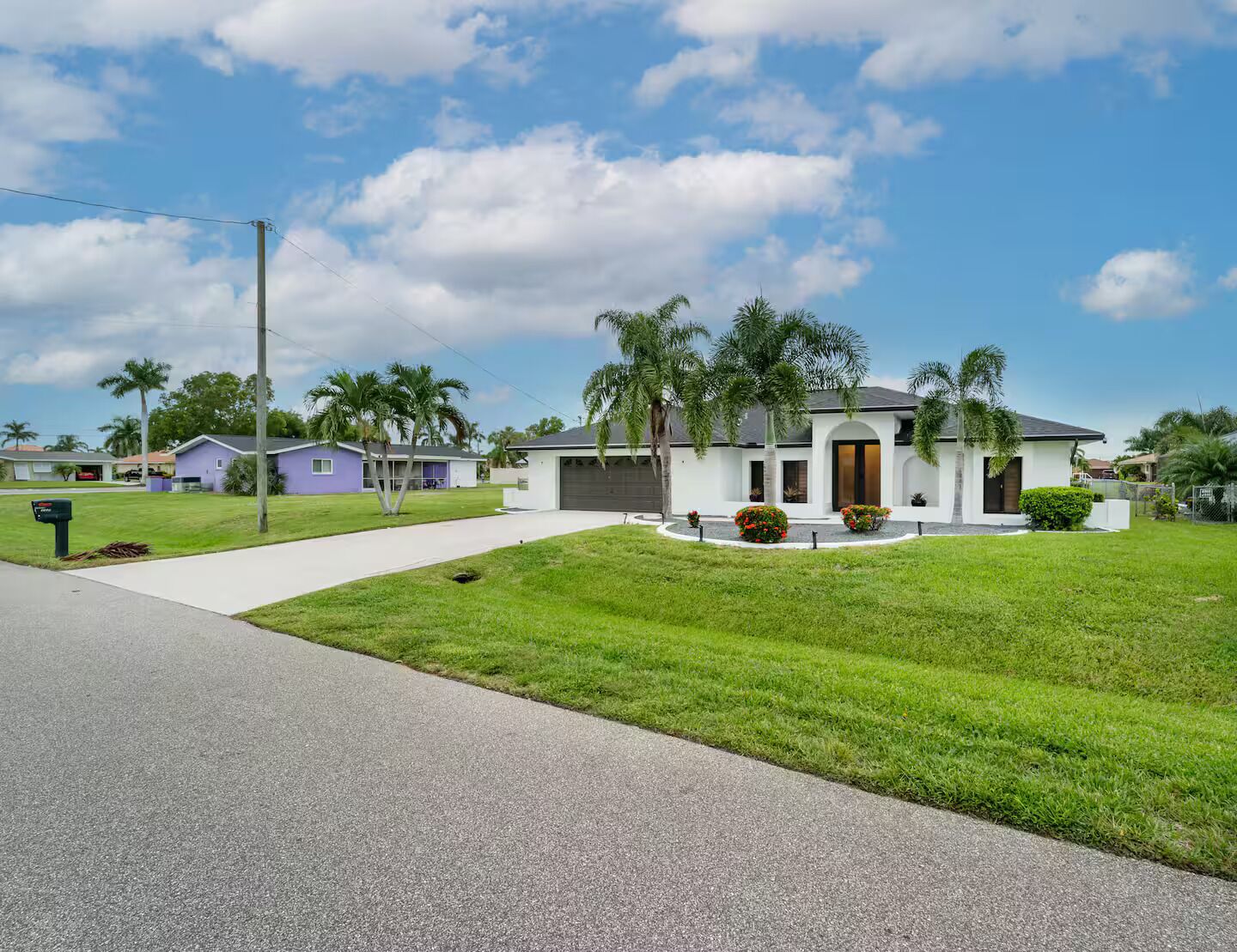 A single-story house with a front porch, a driveway, and a well-maintained lawn.