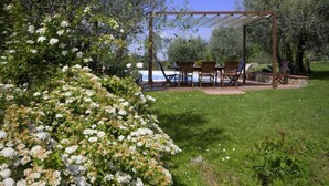 Eine Terrasse im Freien mit einer Pergola, einem Tisch und Stühlen.
