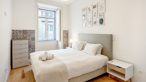 Ein Schlafzimmer mit Bett, Nachttisch und Fenster.