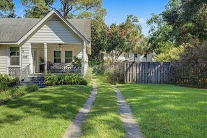 A residential property with a front yard, a pathway leading to the entrance, and a wooden fence.