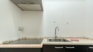 A kitchen with a sink, black cabinets, and a marble countertop. - Estrela House IV by Homing (Lisbon)