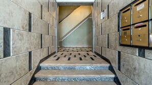 Una escalera de mármol con un piso de diseño geométrico que lleva a una plataforma, donde se ve otra escalera al fondo.