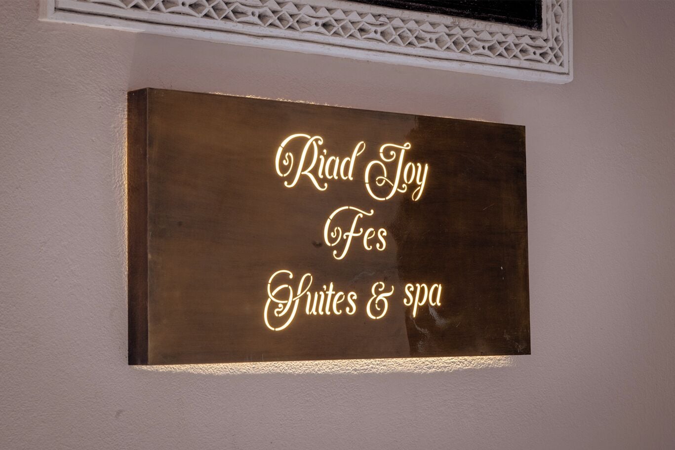 A sign with the text "Riad Loy Suites & spa" indicating a hotel or resort offering suites and spa services.