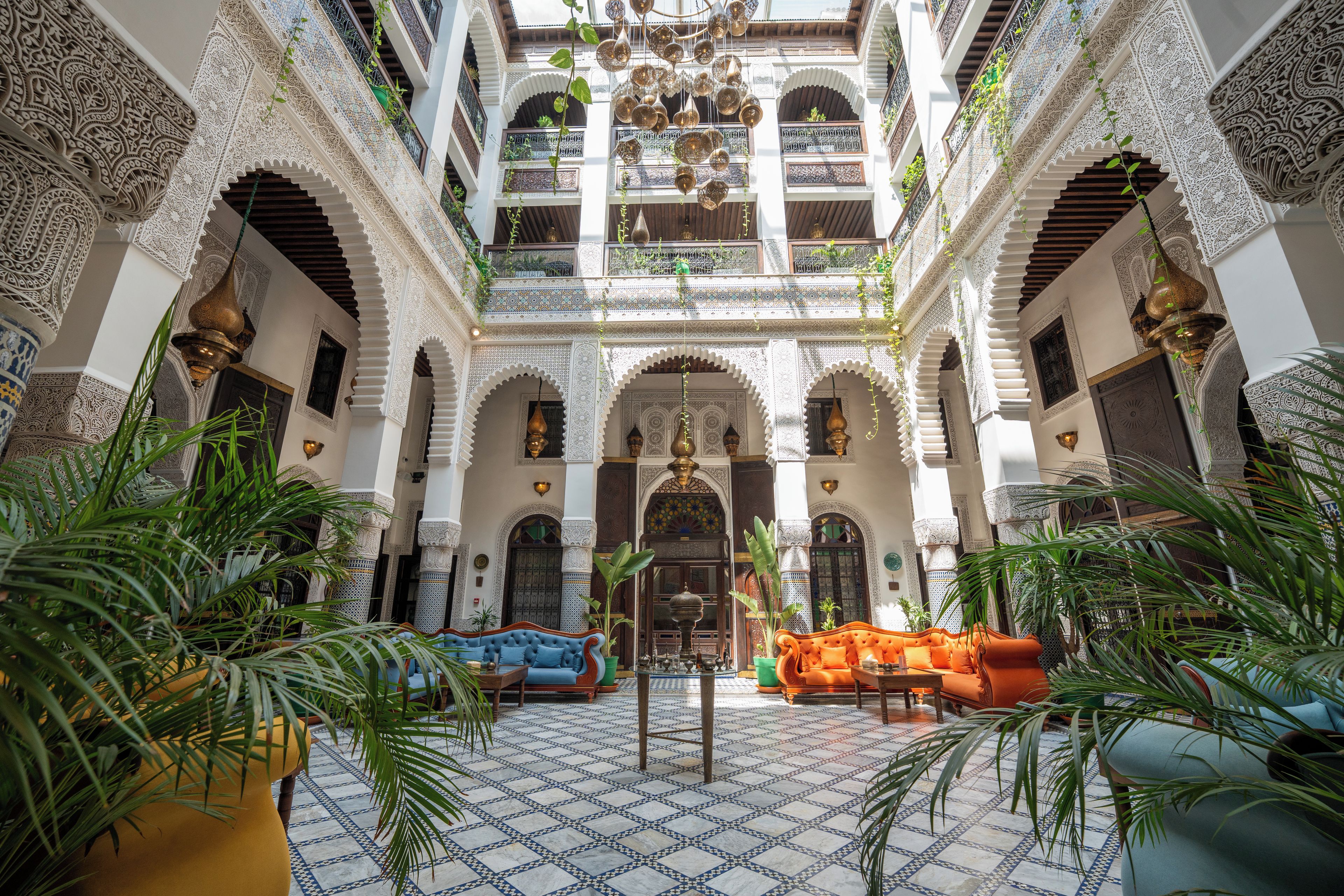An interior courtyard with ornate arches, a central seating area, and a view of the upper floors.