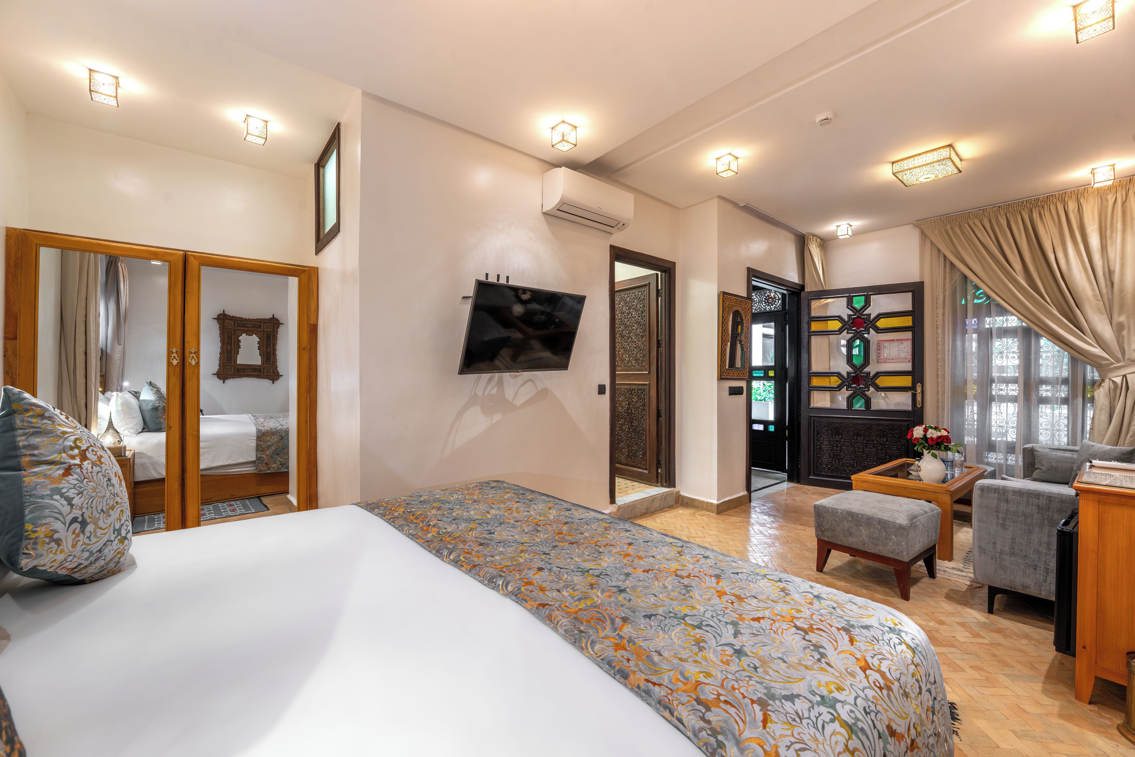 Une chambre d’hôtel avec un lit, un bureau, une chaise et un téléviseur.