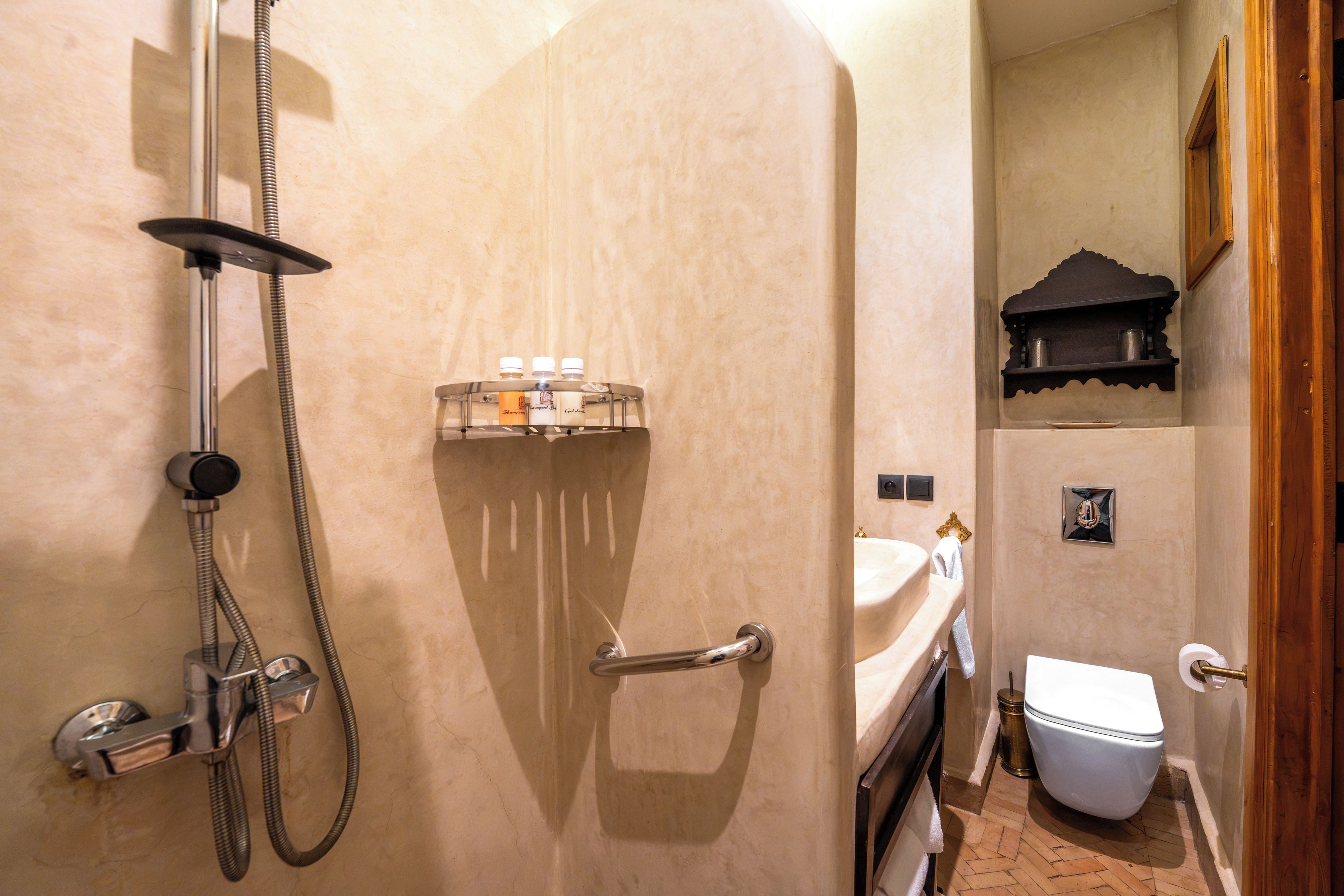 Une salle de bain avec une douche, un lavabo et des toilettes.