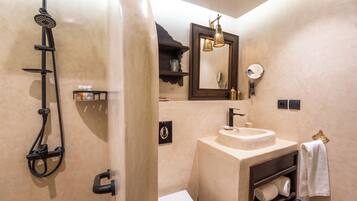 A bathroom with a shower, sink, and mirror.