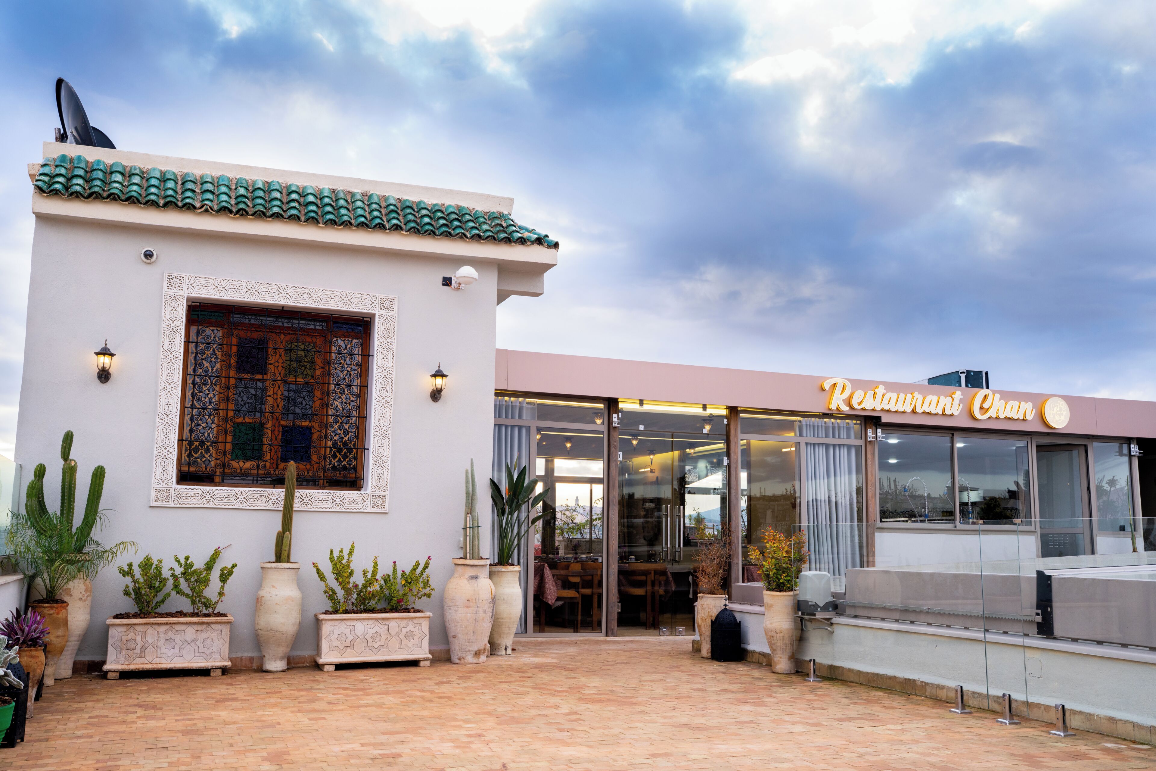En restaurant med en moderne facade, store vinduer og et tegltag.