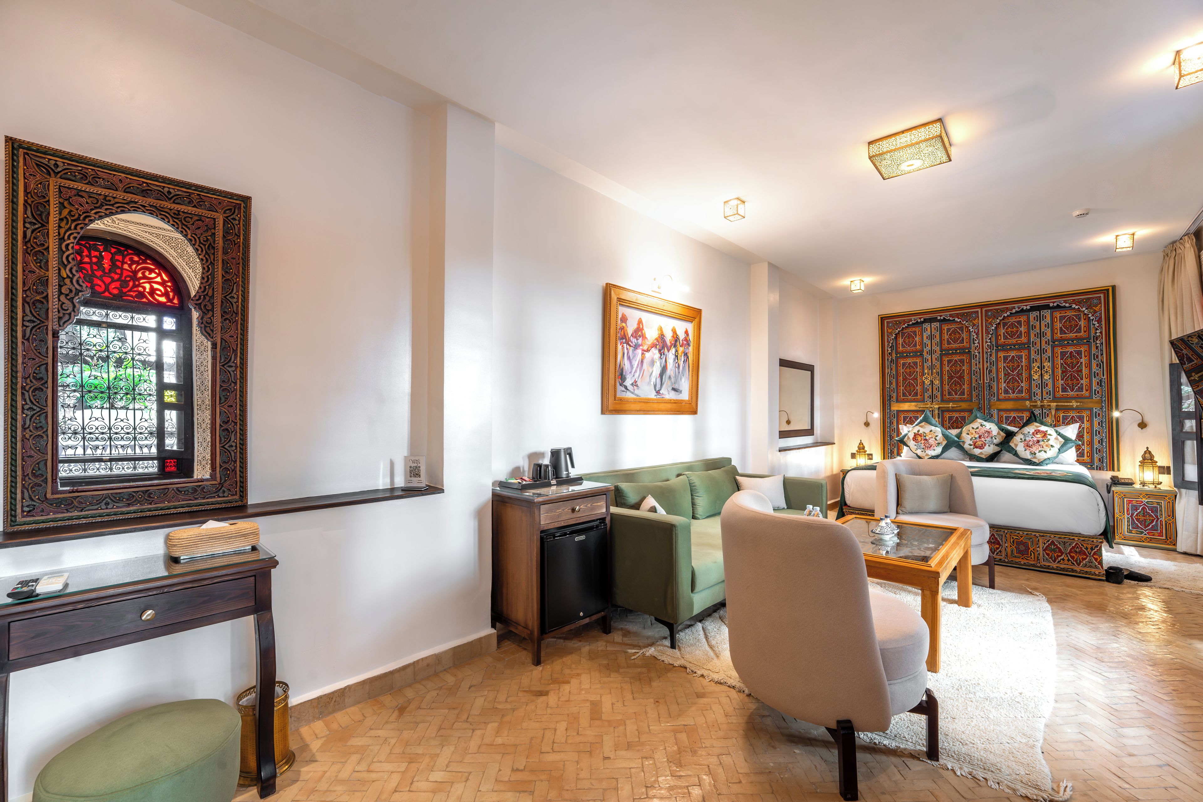 A living room with a green sofa, a coffee table, and a decorative wall with intricate patterns.