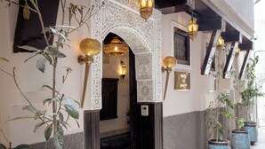 An entrance with intricate white arches and traditional Moroccan lanterns. - Riad Joy (Fes)