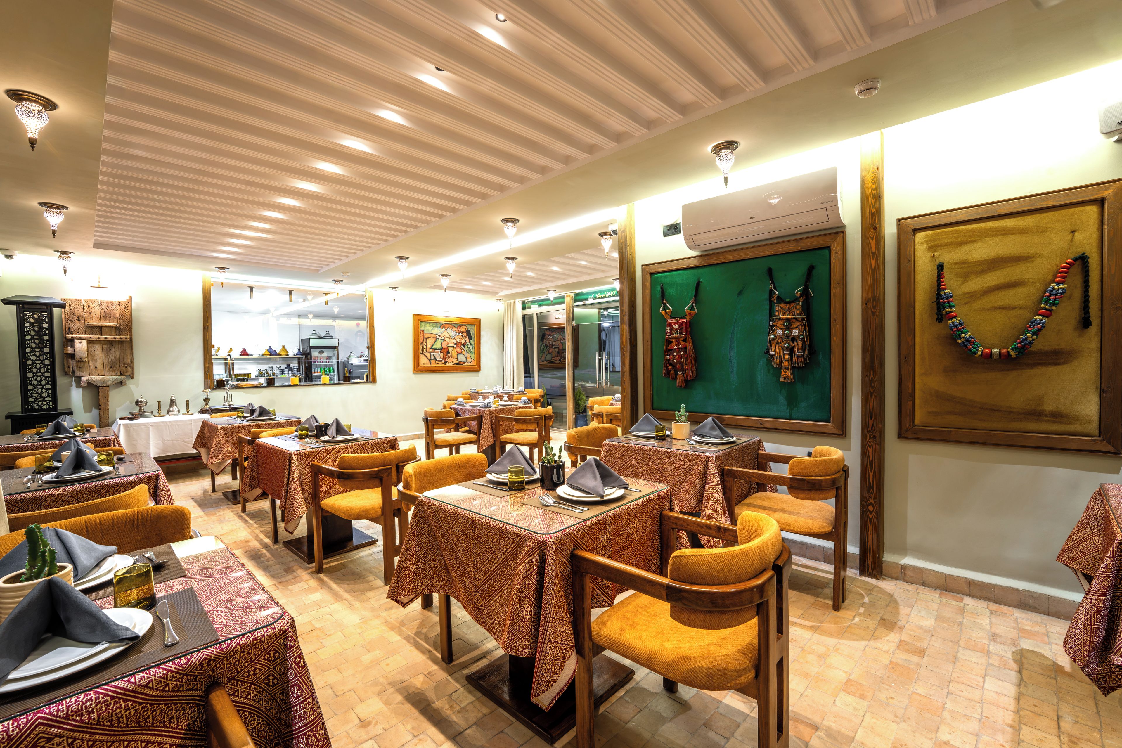 Ein Restaurant mit mehreren Tischen, Stühlen und unterschiedlicher Tischdekoration.