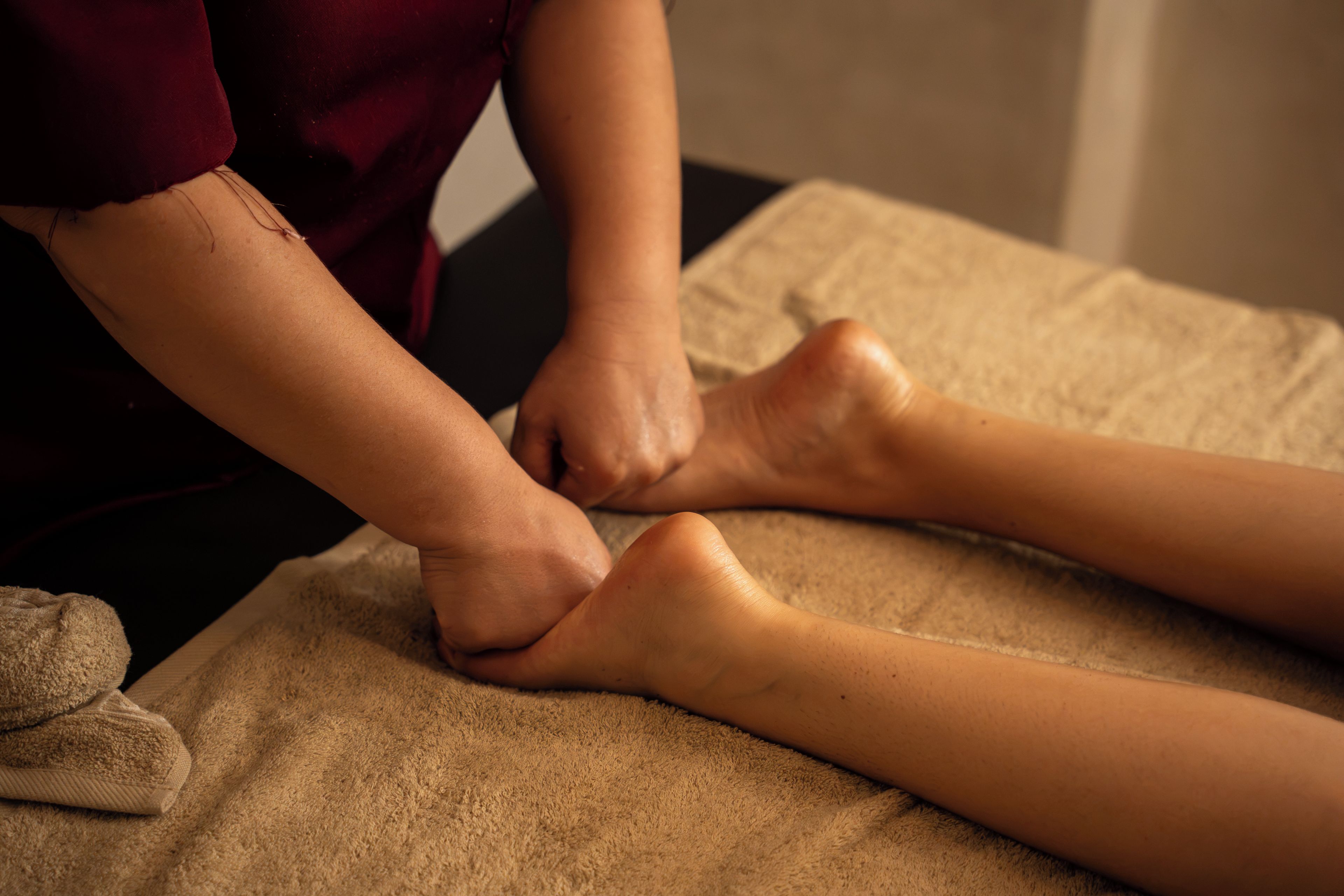 A person receiving a foot massage on a massage table.