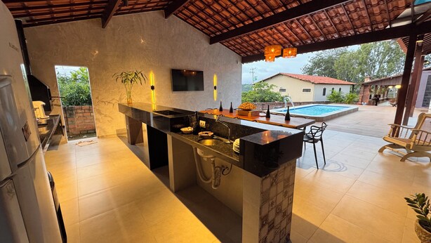 Cozinha moderna com ilha central, pia embutida e vista para uma piscina.