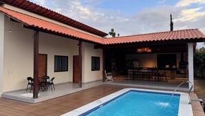 A poolside area with a covered patio, a pool, and a bar area with seating. - The best choice for your family - vacation home with over 600m2 of private space (Gravatá)