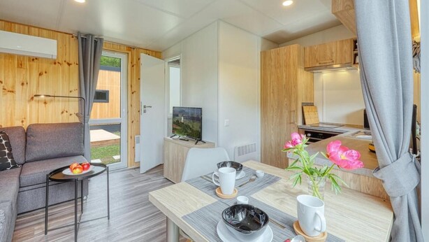 A modern, well-lit room with a sofa, dining table, and kitchen area. - Apartment 'Wemding' with Shared Terrace, Private Garden and Air Conditioning (Wemding)