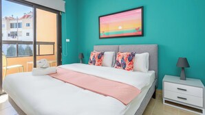 Une chambre à coucher avec un lit, une table de chevet, une fenêtre et un tableau accroché au mur.