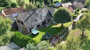 A house with a sloped roof, a hot tub, and a well-maintained lawn.