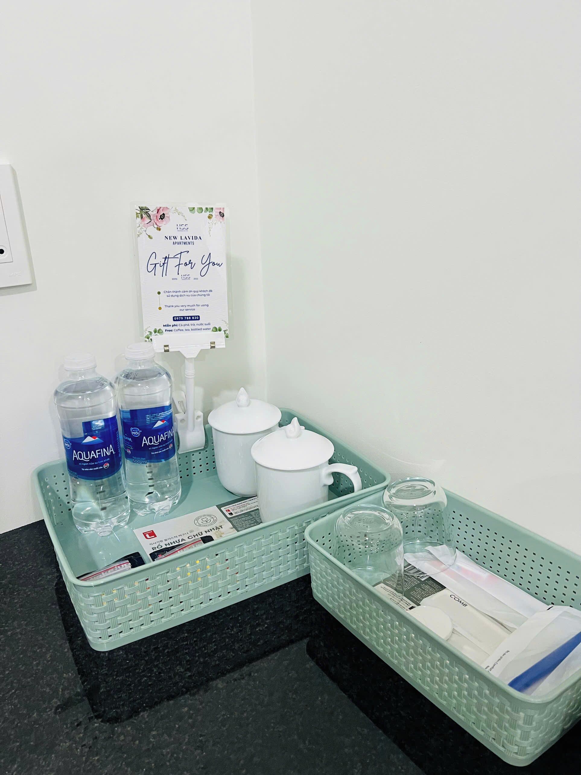 A bathroom counter with toiletries, a framed sign, and a water bottle.