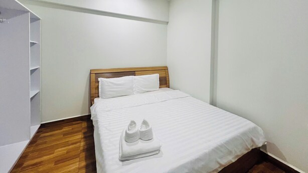 A neatly made bed with white linens and a pair of white slippers placed on it. - New Lavida (Ho Chi Minh City)
