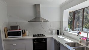 Et moderne køkken med indbygget komfur, mikroovn og opvaskemaskine.