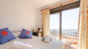 A hotel room with a large bed, two pillows, a nightstand, and a balcony with a railing. - Room + bathroom, splendid sea view, well equipped (Callao Salvaje)