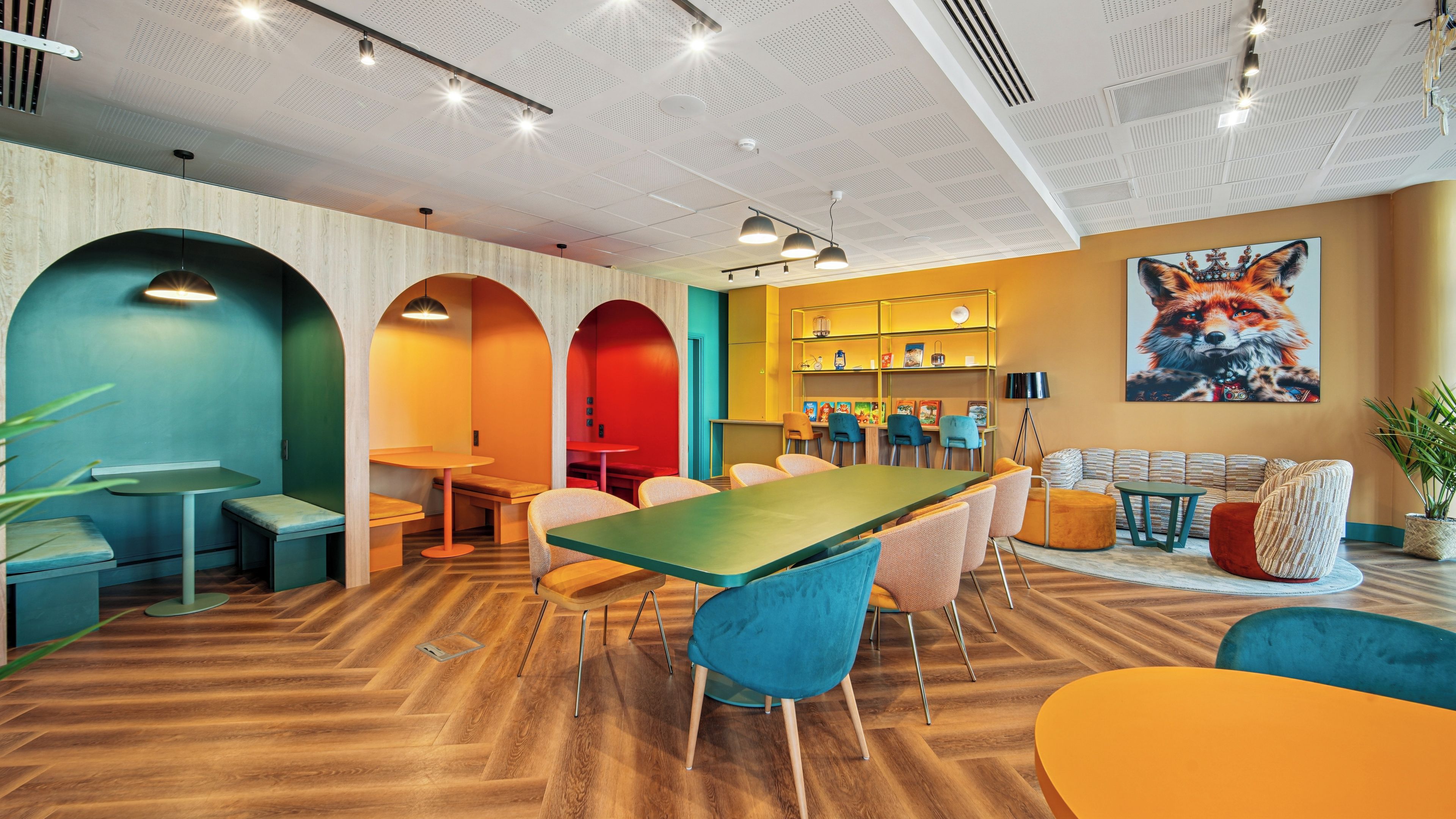 A modern interior with a long table, multiple chairs, and a seating area with sofas.