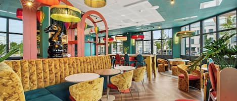 Un intérieur moderne avec des espaces de détente, des tables et de grandes fenêtres.