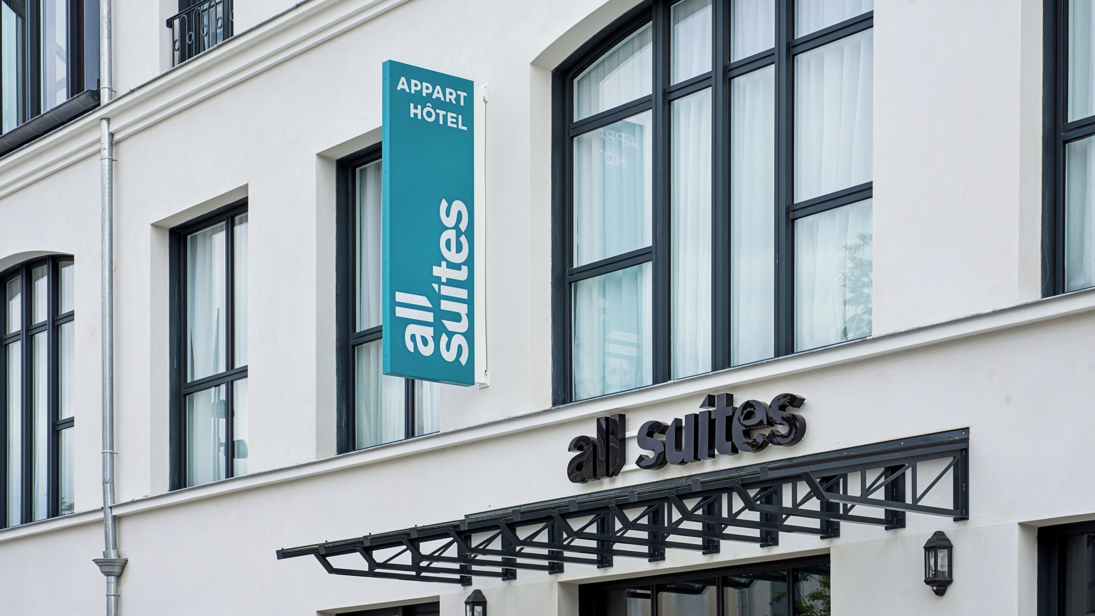 A hotel sign with 'all suites' and 'apartment hotel' indicating a hotel offering suites.