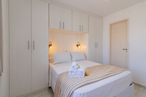 A hotel room with a bed, white wardrobe, and two wall-mounted lights. - 12 Minutes From Copacabana Beach Pl707 (Rio de Janeiro)