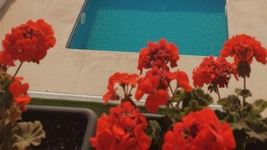 Una piscina con dos secciones separadas, rodeada por una valla blanca y un flotador salvavidas.