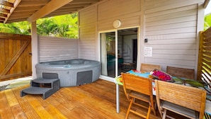 A covered patio with a hot tub, wooden deck, and a table with chairs. - Lodge 2 - Hibiscus - Jaccuzi Privé (Les Anses-d'Arlet)