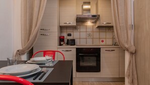 Une cuisine compacte équipée d’une cuisinière, d’un four à micro-ondes et d’une machine à café.