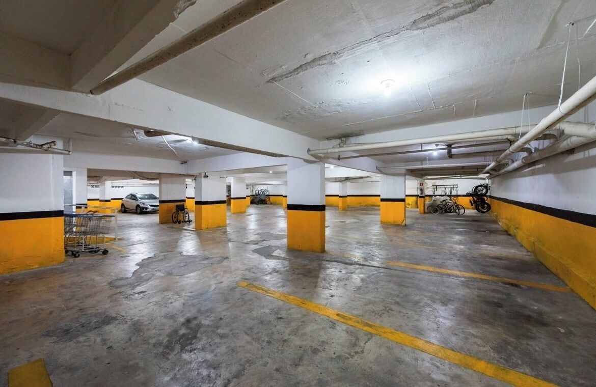 Eine Parkgarage im Innenbereich mit Betonböden und Wänden in Gelb und Weiß.