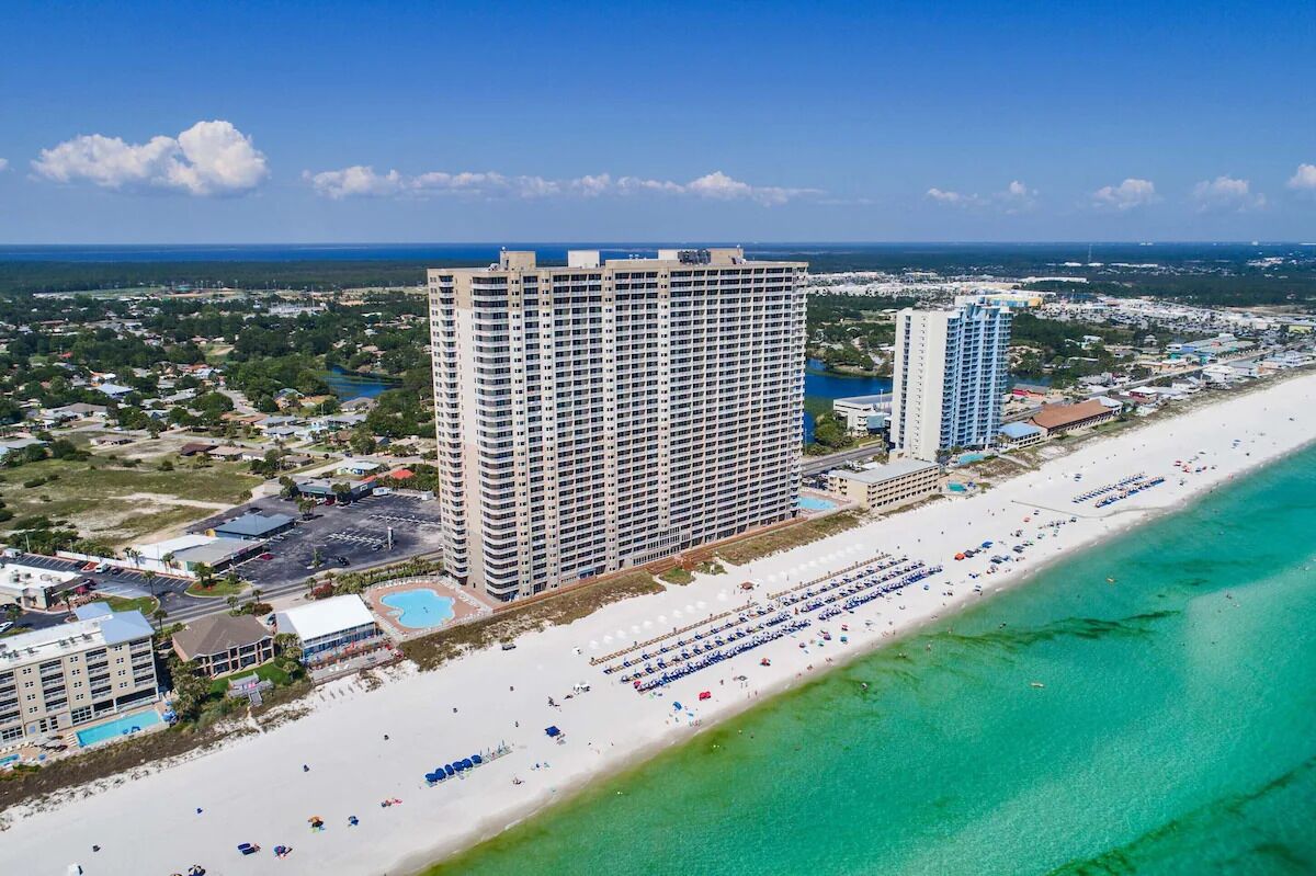 A high-rise hotel with multiple floors, a beachside location, and a pool area.