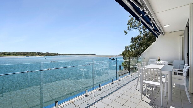 A balcony with a clear view of the sea, white outdoor furniture, and a glass railing. - Mariners Point 5 Noosaville (Noosaville)