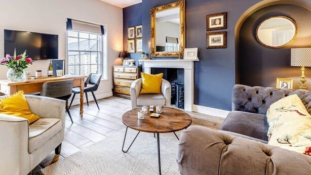 A modern living room with a fireplace, a large mirror, and a television.