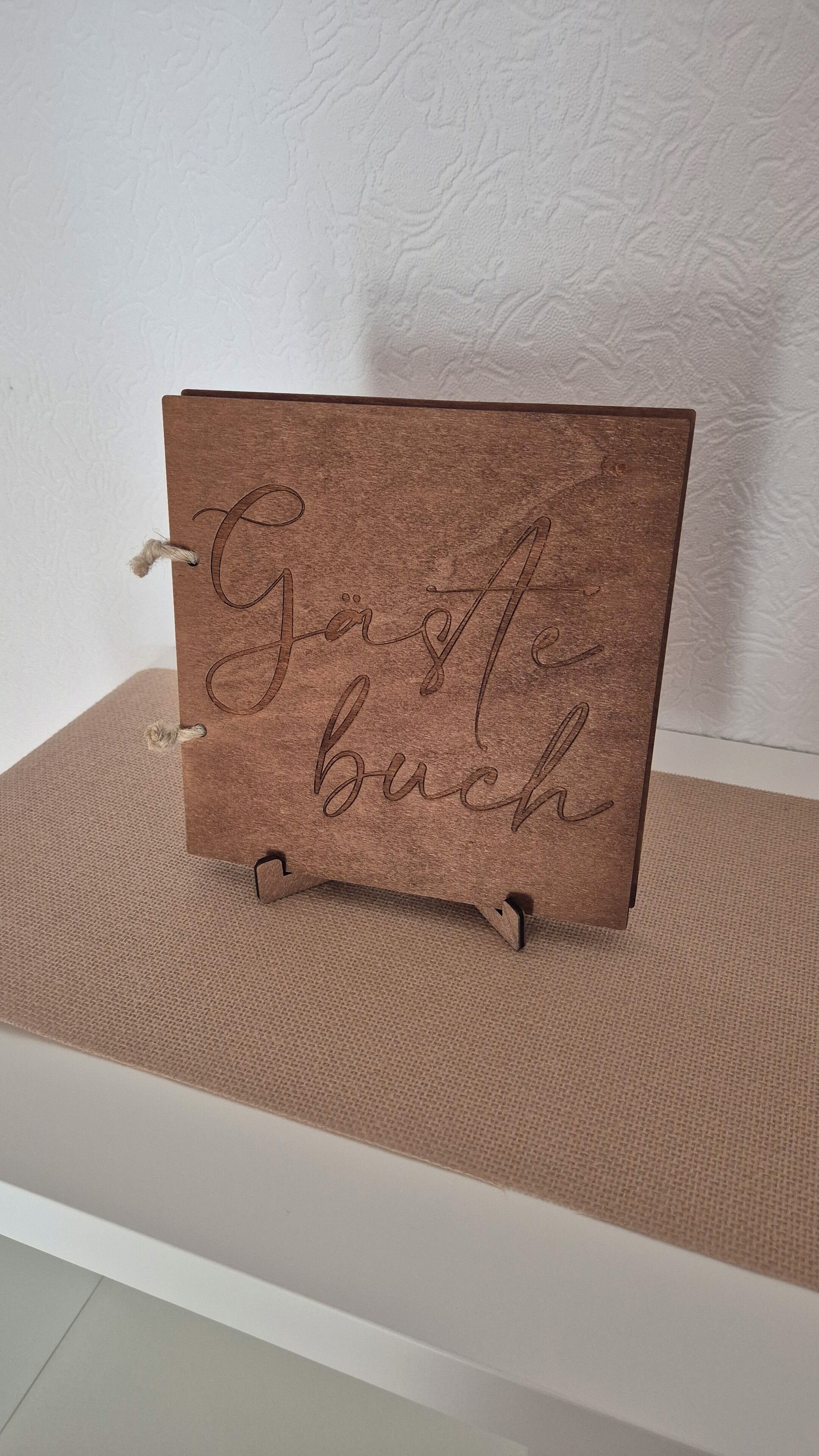 Eine braune Karte mit dem Schriftzug "Danke buch" auf einer strukturierten Oberfläche.