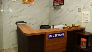 A reception desk with a marble wall background, a clock, a sign for Mount View Inn, and a QR code on the wall.