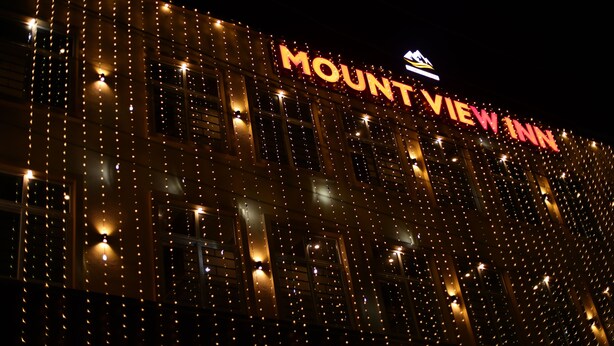 A building with the sign "MOUNT VIEW INN" illuminated at night.