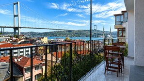 Un balcon avec vue sur un pont, des immeubles et une mosquée.